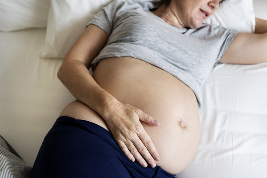 Pregnant woman sleeping on the bed