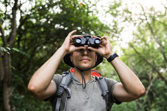 Man holding binoculars in the forest