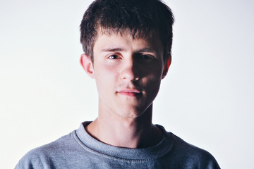 Face of handsome man with fashionable hairstyle half closed in shadow