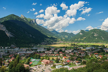 Houses in valley with evergreen mountains and blue sky viewed from the Faverges castle's tower. At the charming village of Faverges. Located at the department of Haute-Savoie, southeastern France.