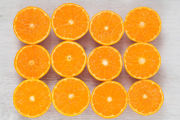 Juicy mandarines cut in half on a wooden background