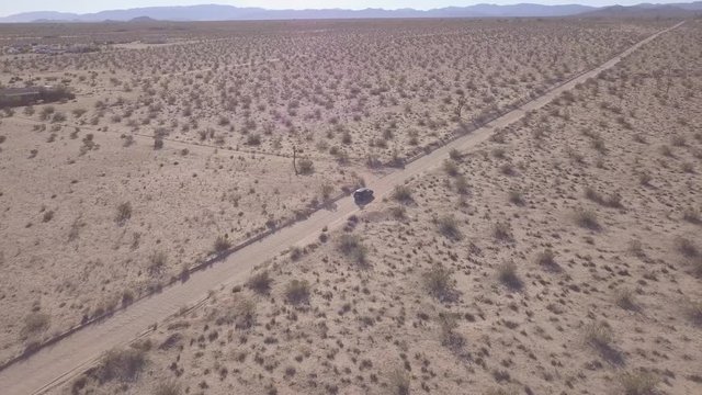 Desert dirt road aerial  tracking vehicle drone