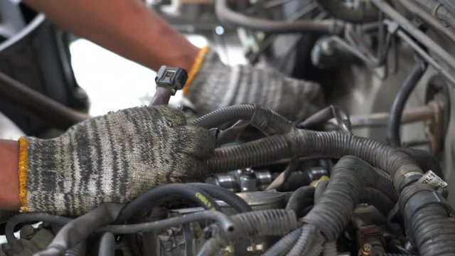 4k movie of mechanic repairing an old car. Under the hood of the car checks the work of carb and engine