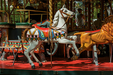 Fototapeta na wymiar Colorful carousel with white horse in a park of Annecy. An historical and lovely lakeside town located at the department of Haute-Savoie, southeastern France.