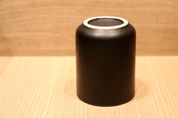 Black teacup put upside down on the wooden floor. It is a cup from which tea is drunk.
