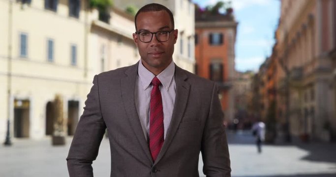 Confident African-American professional posing outside in an Italian setting, Young successful black businessman standing confidently in an Italian street, 4k