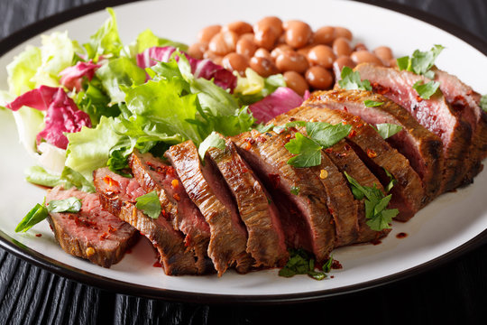 Mexican freshly prepared sliced beef steak with lettuce and beans close-up. horizontal