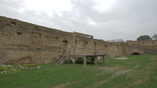 A wooden gallows in a medieval courtyard