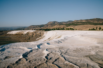 natural view of white rocks and beautiful mountains in pamukkale, turkey