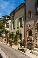 Fototapeta na wymiar Street view with stone houses in the center of the village of Chateauneuf-du-Pape, blue sky and sunny day. Located in the Vaucluse department, Provence-Alpes-Côte d'Azur region in southeastern France