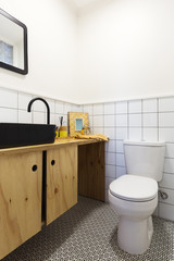 Renovated powder room with decorative floor tiles and black vanity