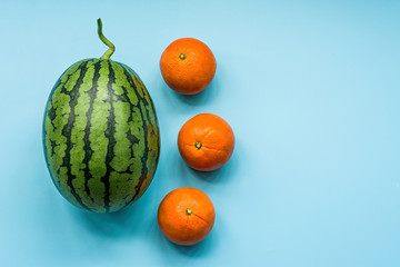 creative layout of a watermelon and oranges on blue background