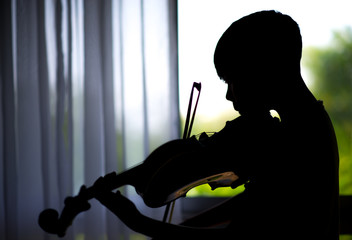 silhouette Little boys play and practice violin in the music class room