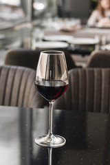 Wineglass with red wine on black table