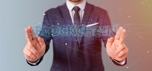 Businessman holding a Blockchain title isolated on a background
