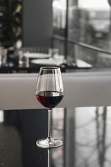 Wineglass with red wine on black table