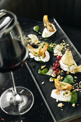 Wineglass with red wine and antipasti set on table in cafe