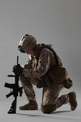 Soldier in camouflage holding rifle