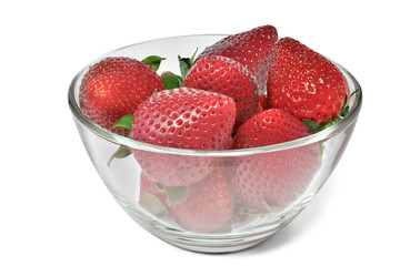 Ripe strawberry in glass bowl close up isolated on white background