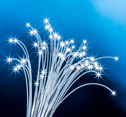 Naklejka premium Bundle of optical fibers with lights in the ends. Blue background.