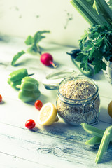 Bowl of assorted fresh seasonal spring summer vegetables on white shabby table, super food grains seeds, oats pumpkin and chia seeds dried plum fruits, healthy snacks clean eating concept, copy space
