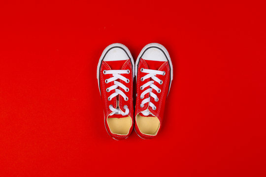 Red sneakers top view close up on colorful background