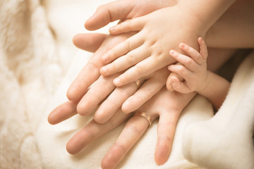 Newborn child hand. Closeup of baby hand into parents hands. Family, maternity and birth concept.