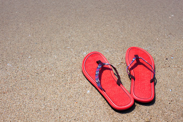 Fototapeta na wymiar Flip flops on the sandy beach