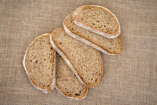 Sliced brown bread on burlap.