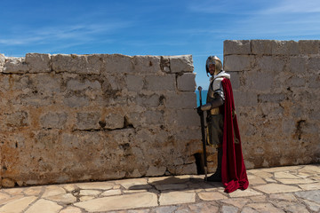 Medieval Templar soldier watches the coastline from the wall