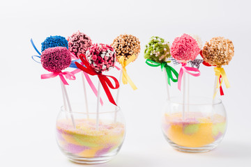 Set of colored Cake pop in a glass vase on a white background close