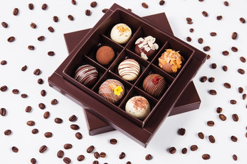 handmade chocolates in a square box and coffee beans around