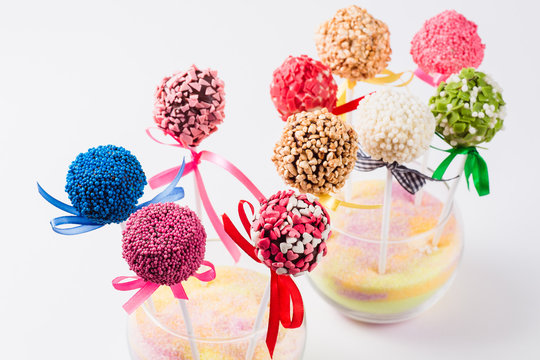 Set of colored Cake pop in a glass vase on a white background close