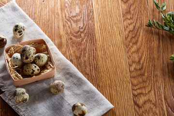 Quail eggs in the container over rustic wooden table, close-up, high angle view, selective focus.