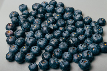 large, fresh blueberries lie on a gray plate, close-up