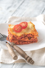 Portion of lasagne on the white plate