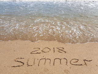 the word Summer 2018 written on the sand, nobody.