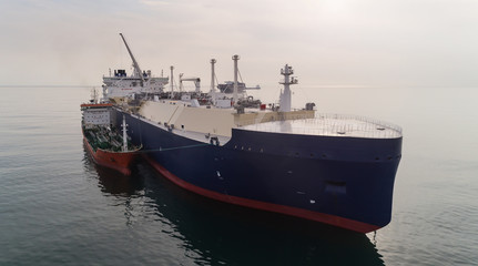 A small tanker on the roadstead bunkers a large LNG tanker.