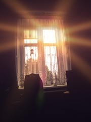 Widok na słońce przez okno w pokoju