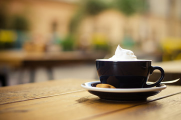 Fresh coffee with whipped cream on a wooden table