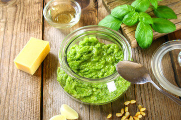Homemade pesto sauce. Ingredients. Cheese, garlic, basil, pine nuts, olive oil on an old wooden table.