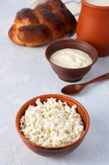 Fresh homemade cottage cheese in brown clay bowl. Close-up view