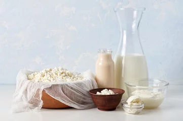 Fototapete Milchprodukte Satz Milchprodukte auf hellblauem Hintergrund. Hüttenkäse, Sauerrahm, Mascarpone und fermentierte Backmilch