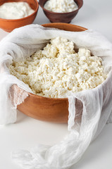 Preparation fresh cottage cheese with cheesecloth in wooden bowl