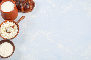 Challah bread with poppy seeds and set of dairy products comprising cottage cheese, sour cream and whole milk