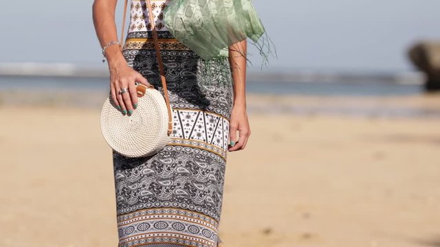 Woman with fashionable stylish rattan bag on the beach. Tropical island of Bali. Handmade Rattan eco handbag HD footage.