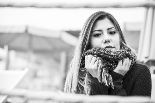 Foto B/n di Giovane donna bionda, che si tiene la sciarpa e guarda in macchina