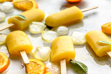 Orange popsicle with fresh oranges and ice, summer refreshing concept