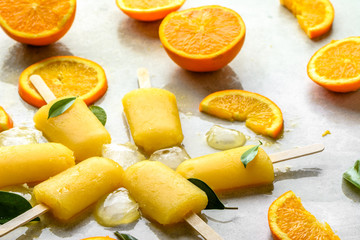Orange popsicles with frozen juice and ice cubes, summer refreshing snack