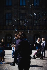 Woman Looking At Floating Bubbles In The City
